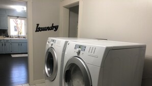 Ein Waschraum mit zwei Waschmaschinen mit Frontlader und einem Schild mit der Aufschrift 'Laundry'.