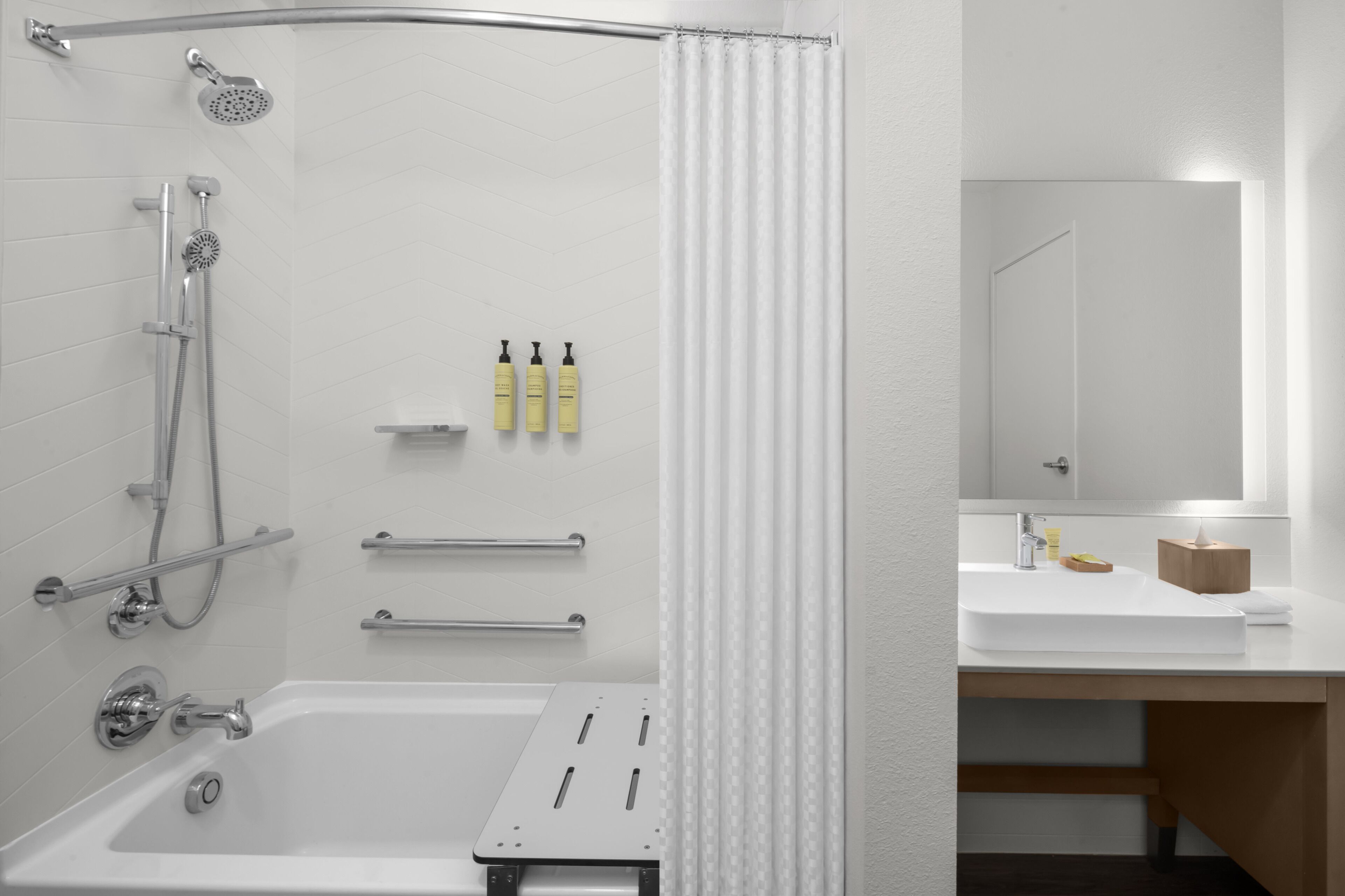 Ein modernes Badezimmer mit Badewanne, Dusche und einem Waschtisch mit Spiegel.