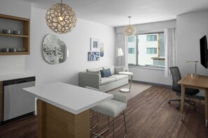 A modern hotel room with a kitchenette, a dining area, a sofa, a TV, and a large window with curtains. - Element by Marriott North Austin Tech Ridge (Austin)