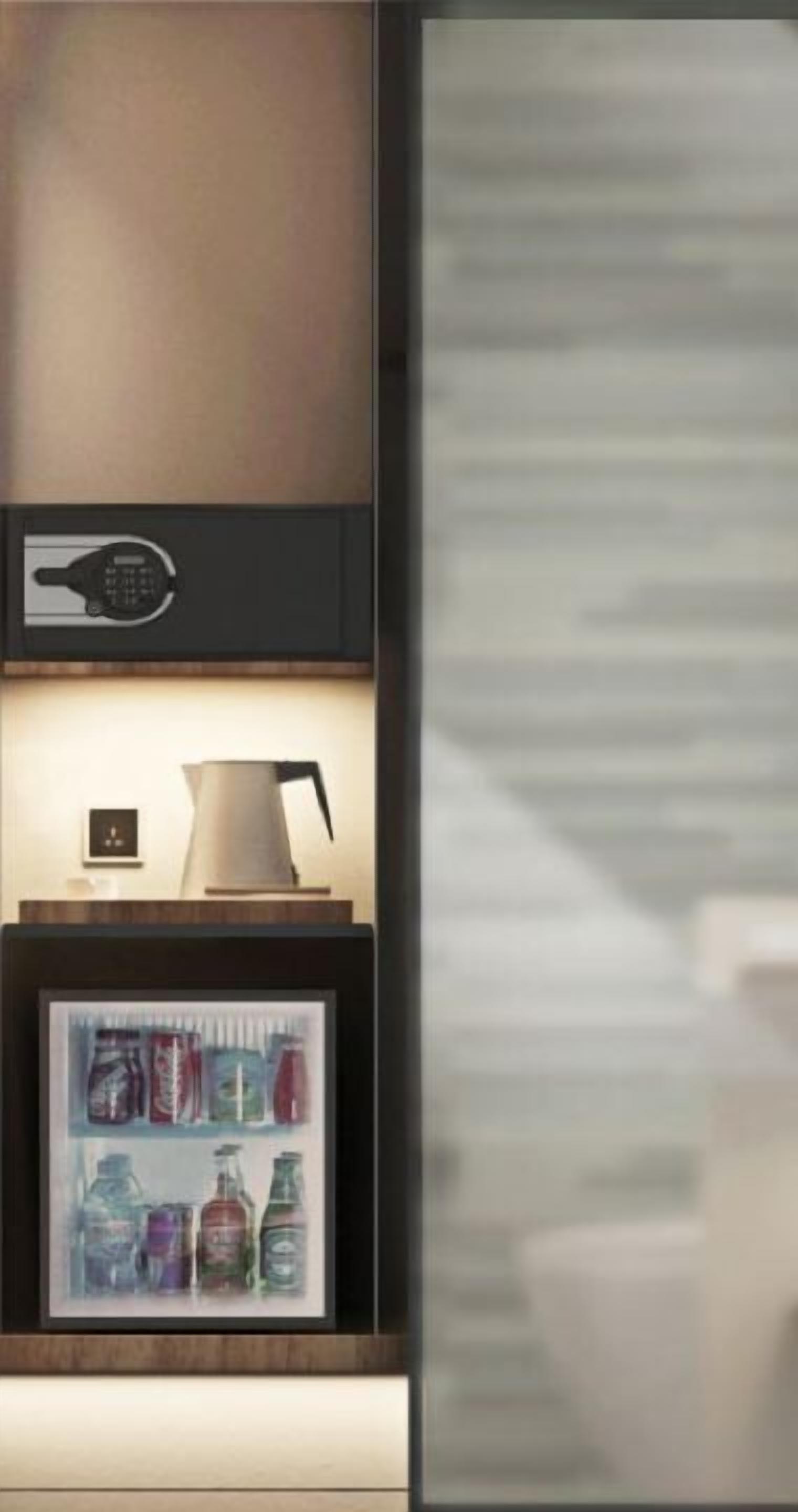 A modern kitchen with a built-in coffee machine, a kettle, and a framed picture of canned beverages.