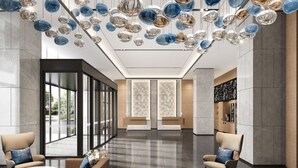 A modern lobby with a seating area, large windows, and decorative hanging lights. - Fairfield by Marriott Hangzhou Qiantang (Hangzhou)