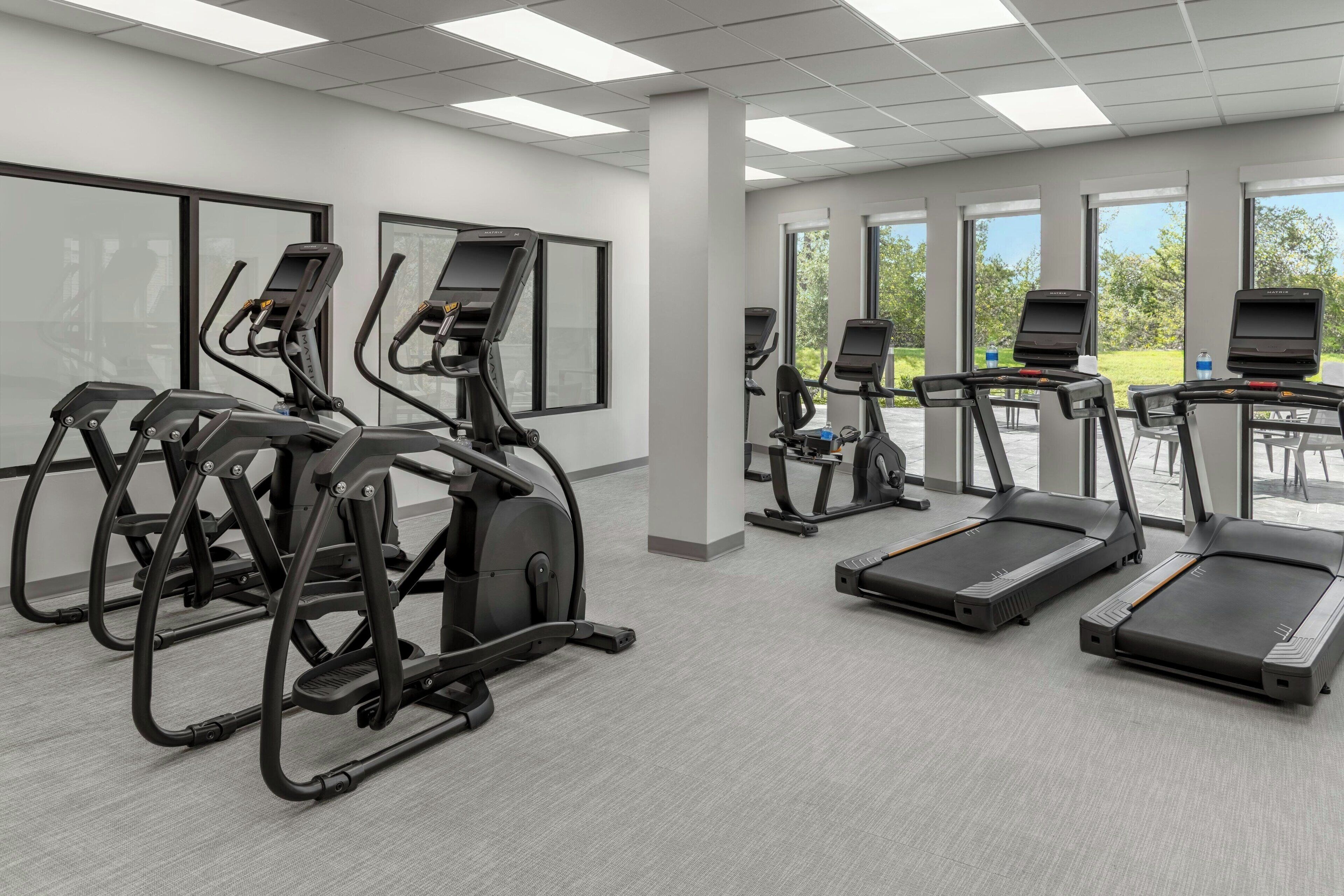 A gym with treadmills, elliptical machines, and stationary bikes.
