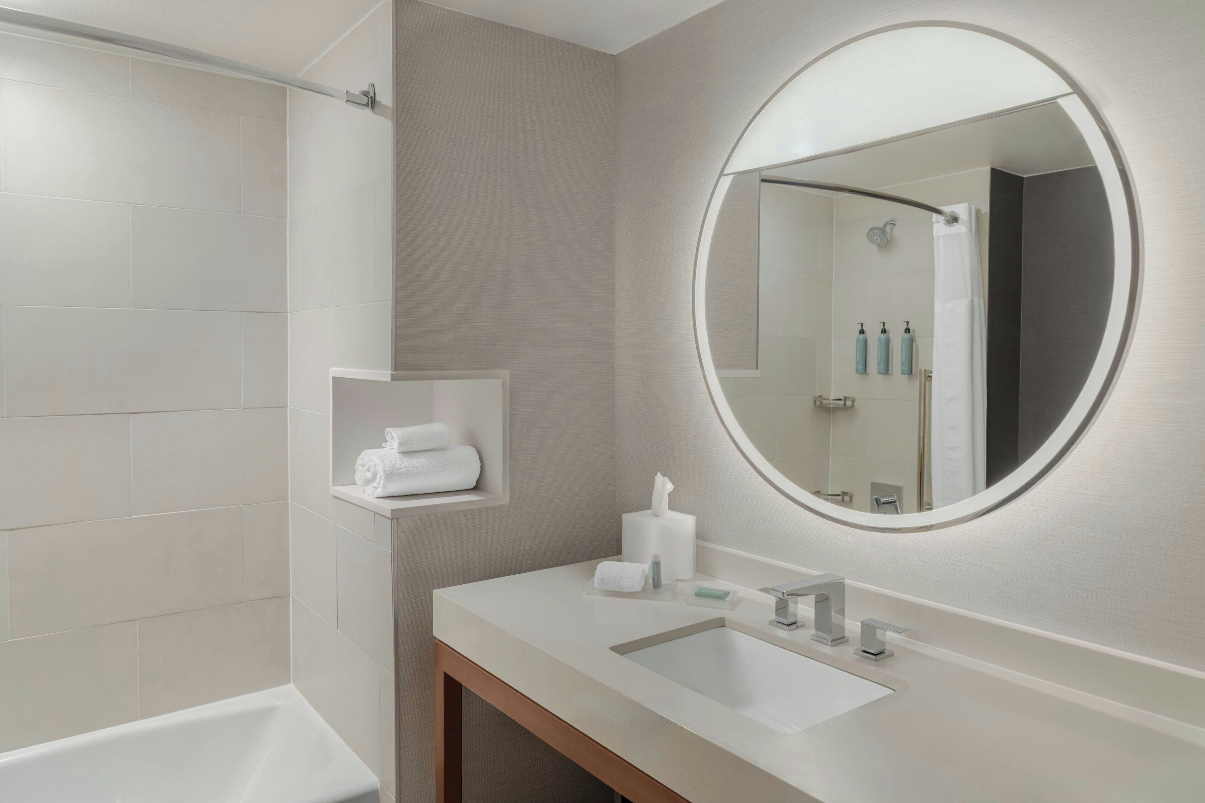 Un baño moderno con bañera, lavabo y espejo.