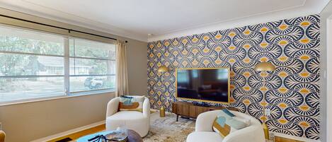 Relax in style with a large flat-screen TV, comfortable armchairs, and a cozy reading nook.