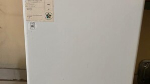 Un refrigerador blanco con un adhesivo en la puerta.