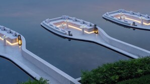 A modern outdoor lounge area with seating and tables, surrounded by water. - Hotel Indigo Hainan Clear Water Bay by IHG (Lingshui)