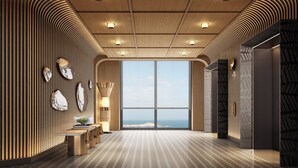 A modern hotel lobby with a wooden ceiling, a patterned floor, and a large window offering a view of the sea. - Hotel Indigo Hainan Clear Water Bay by IHG (Lingshui)