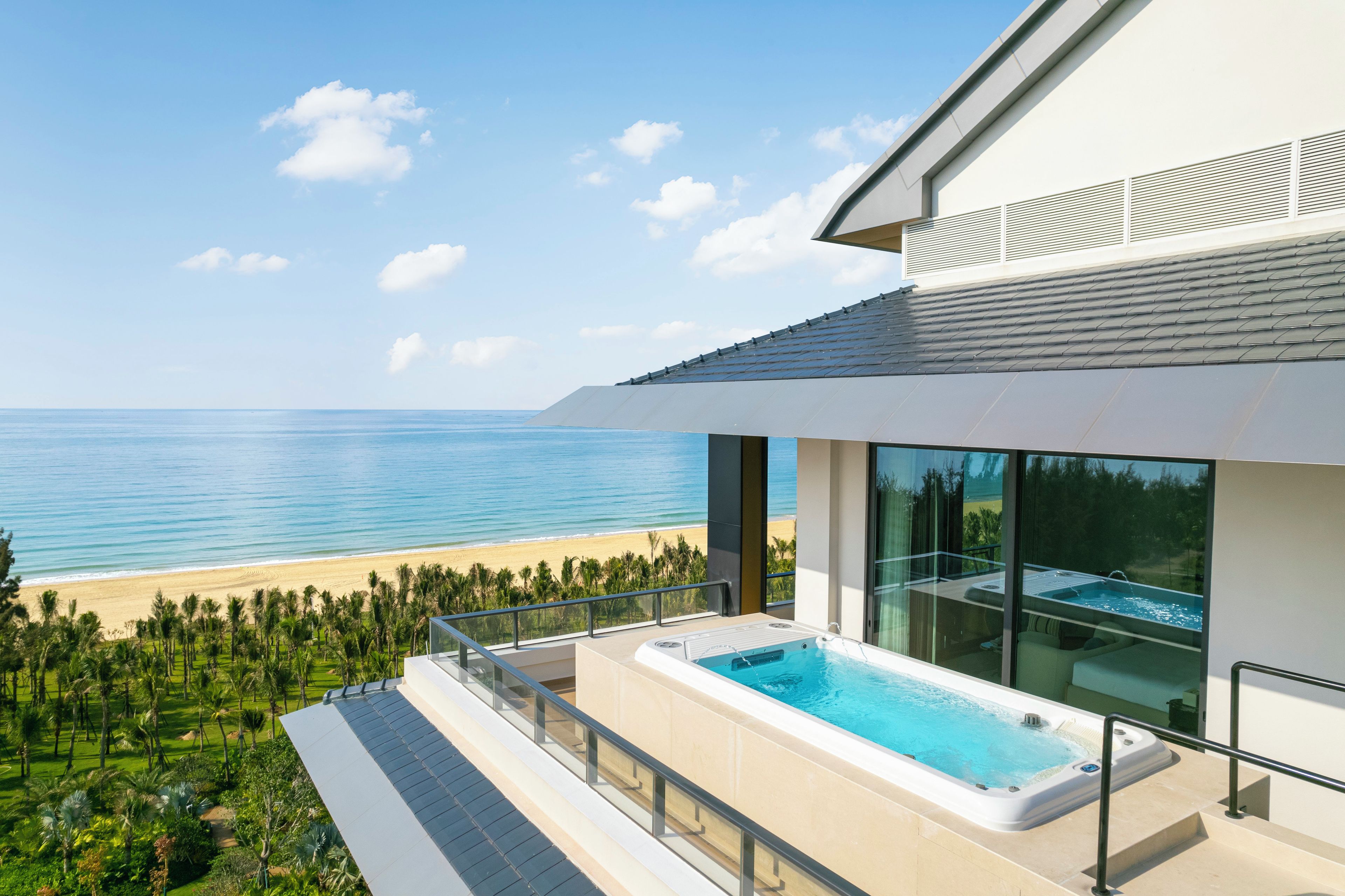 A modern building with a swimming pool and a view of the beach.