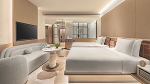 A modern hotel room with a large bed, a sofa, a TV, and a small table with a plant. - Hotel Indigo Hainan Clear Water Bay by IHG (Lingshui)