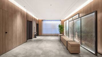 A modern hallway with wooden paneling, a bench, and a large window with a view.