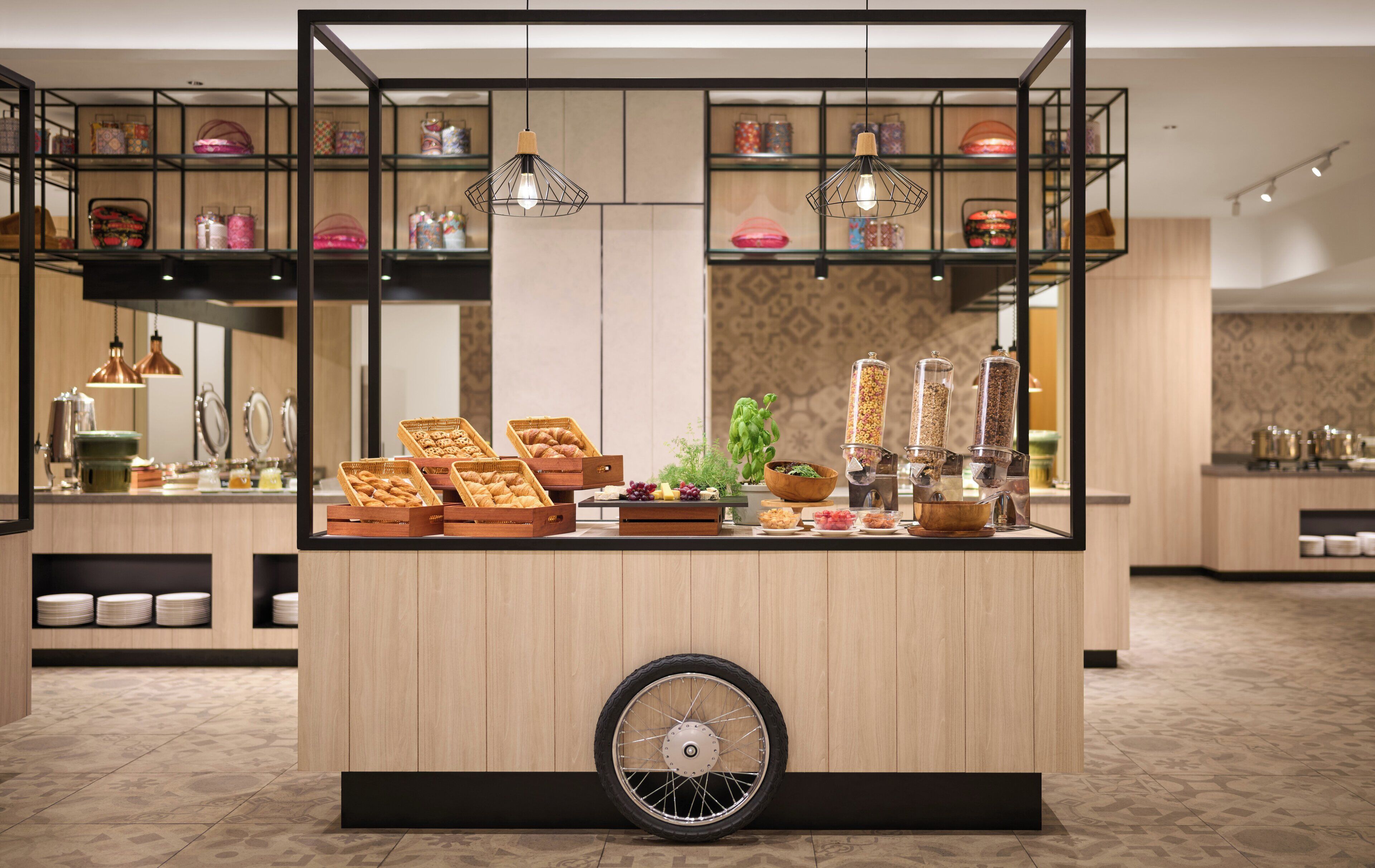 A breakfast bar with a unique wheel design, surrounded by shelves with jars and a variety of food items.