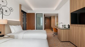 A hotel room with a bed, a desk, a TV, and a bathroom visible through an open door. - Holiday Inn & Suites Penang Prai by IHG (Bukit Mertajam)