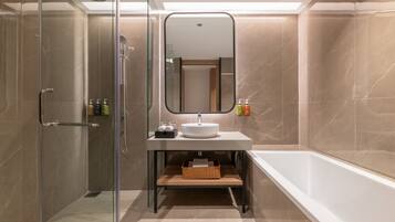 Un baño moderno con cabina de ducha de vidrio, un lavabo blanco y una bañera.