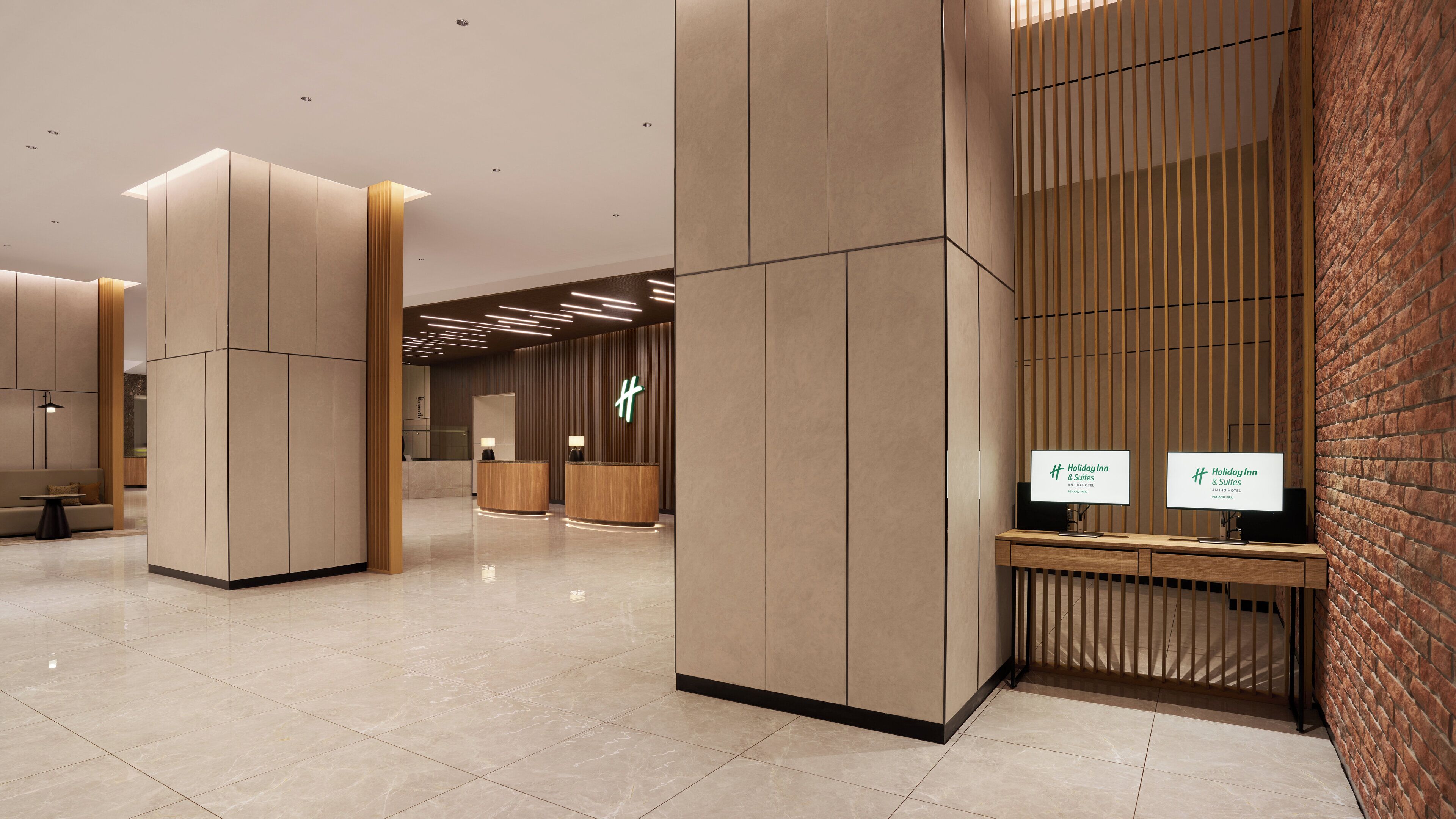 A modern hotel reception area with a minimalist design, featuring a reception desk, seating area, and a large brick wall.
