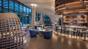 A modern bar area with seating and a bar counter, large windows, and a unique architectural design. - Crowne Plaza Sanya Yazhou Bay by IHG (Sanya)