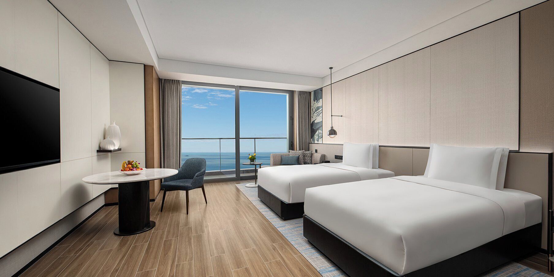 Une chambre d’hôtel moderne avec une grande fenêtre, deux lits, un bureau et une chaise.