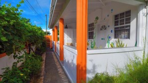 A narrow alleyway with a white building featuring orange pillars and a mural of sea creatures. - Cozy studio in gorgeous Soufriere with WiFi, AC (Soufriere)