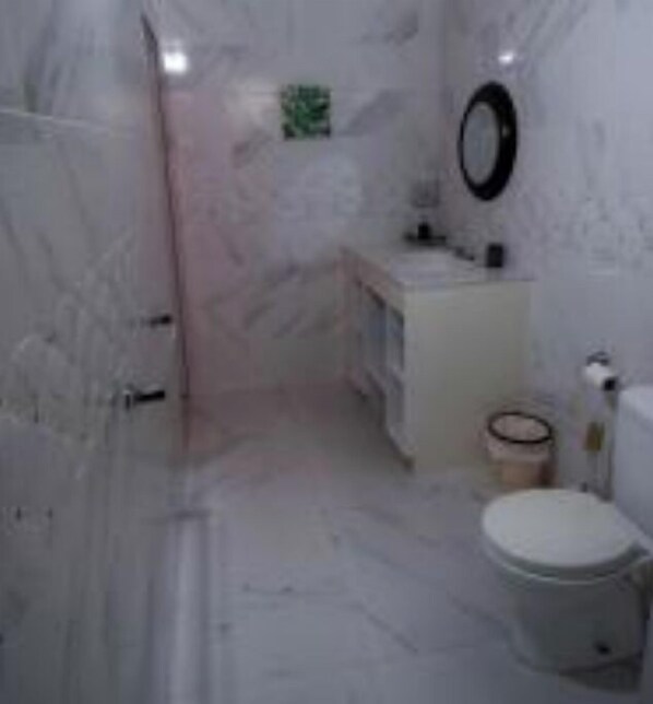 Bathroom features a sink, mirror, toilet, and shower area.