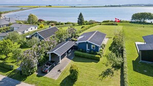 Een woonwijk met huizen, een oprit en een vlag.