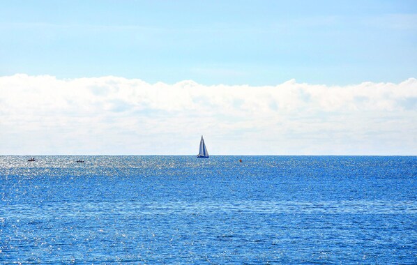 Un voilier sur une mer calme, sous un ciel dégagé.