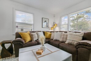Relax in this stylish living room with a comfortable sofa, coffee table, and framed artwork.