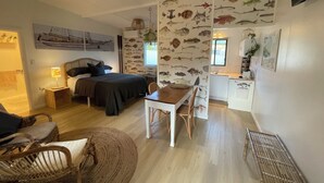 A compact bedroom with a bed, bedside table, and a ceiling fan.