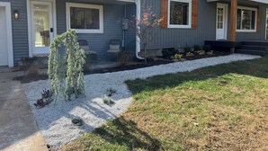 A two-story house with a front porch, a small garden with gravel and plants, and a clear blue sky. - Huge home w/ 4 king beds and a huger yard. On Grand River on 11 acres (Ada)