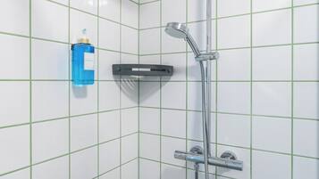 A shower with a handheld showerhead and a handheld faucet.