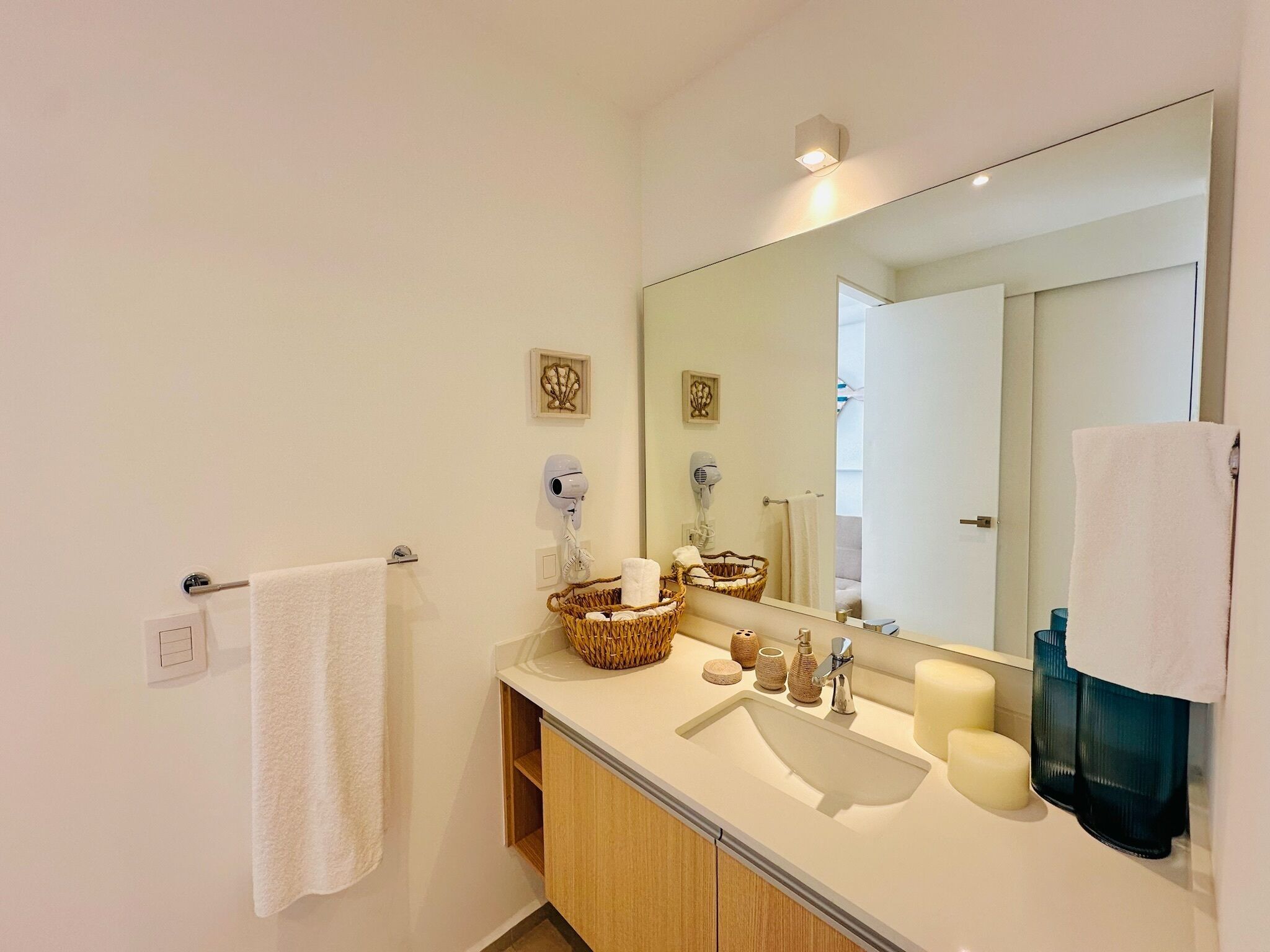 Une salle de bain moderne avec un grand miroir, un lavabo et un porte-serviettes.