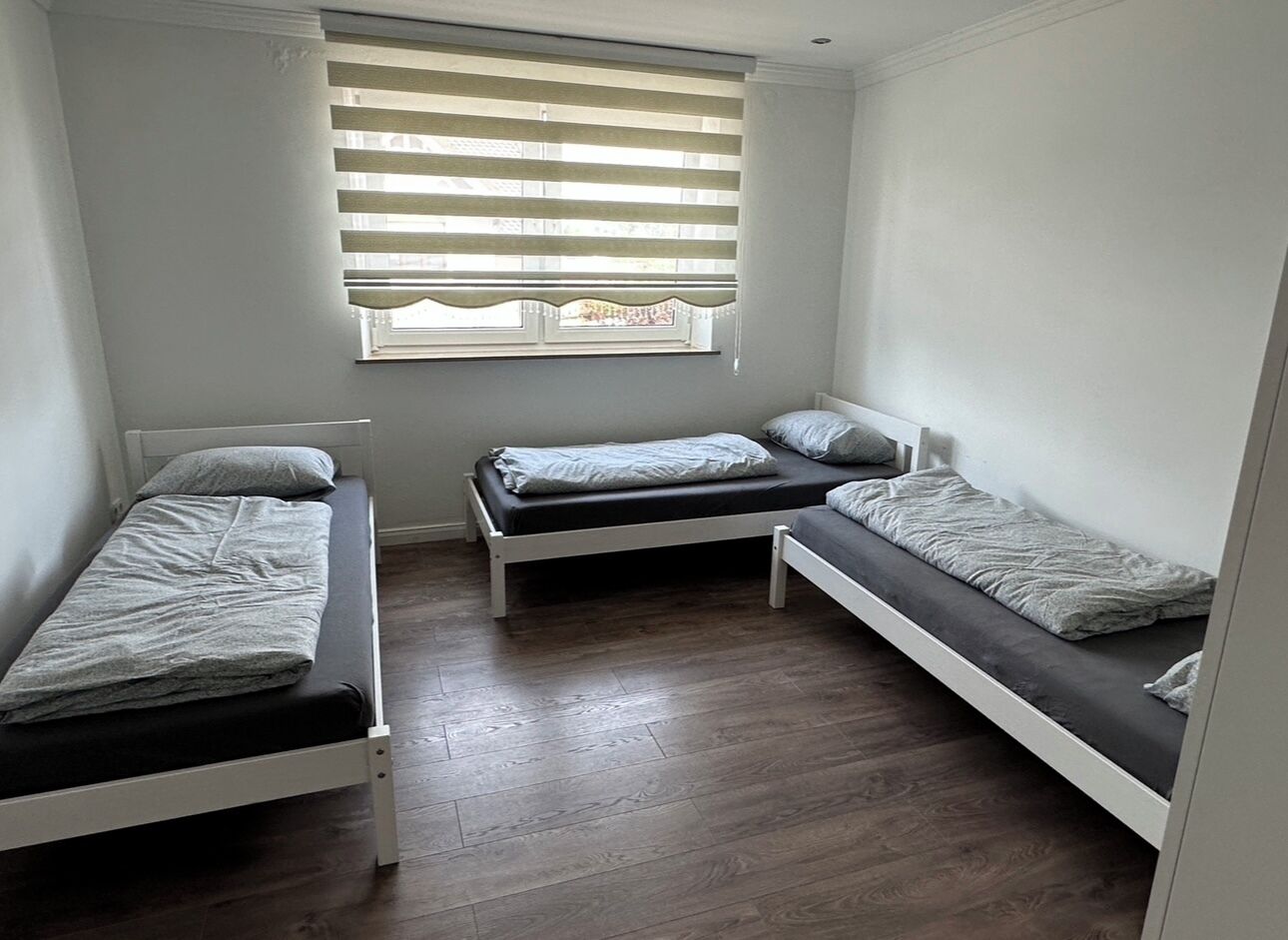 A small, compact room with three bunk beds arranged in a row.