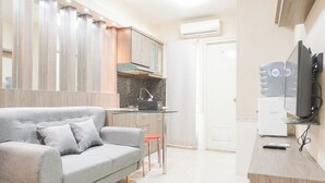 Eine moderne Küche mit grauem Sofa, einem kleinen Tisch und einem Wasserspender.
