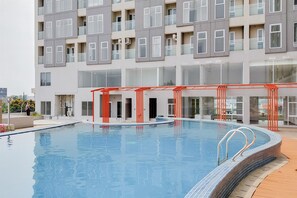 Enjoy a refreshing swim in the pool surrounded by a spacious deck with a safety railing.