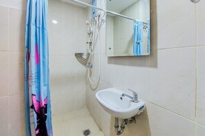 Bathroom features a sink, handheld showerhead, and mirror.