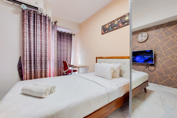 Relax in a stylish room with a comfortable bed, TV, and a convenient work area.