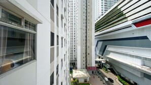 A high-rise residential building with multiple balconies and a central courtyard.