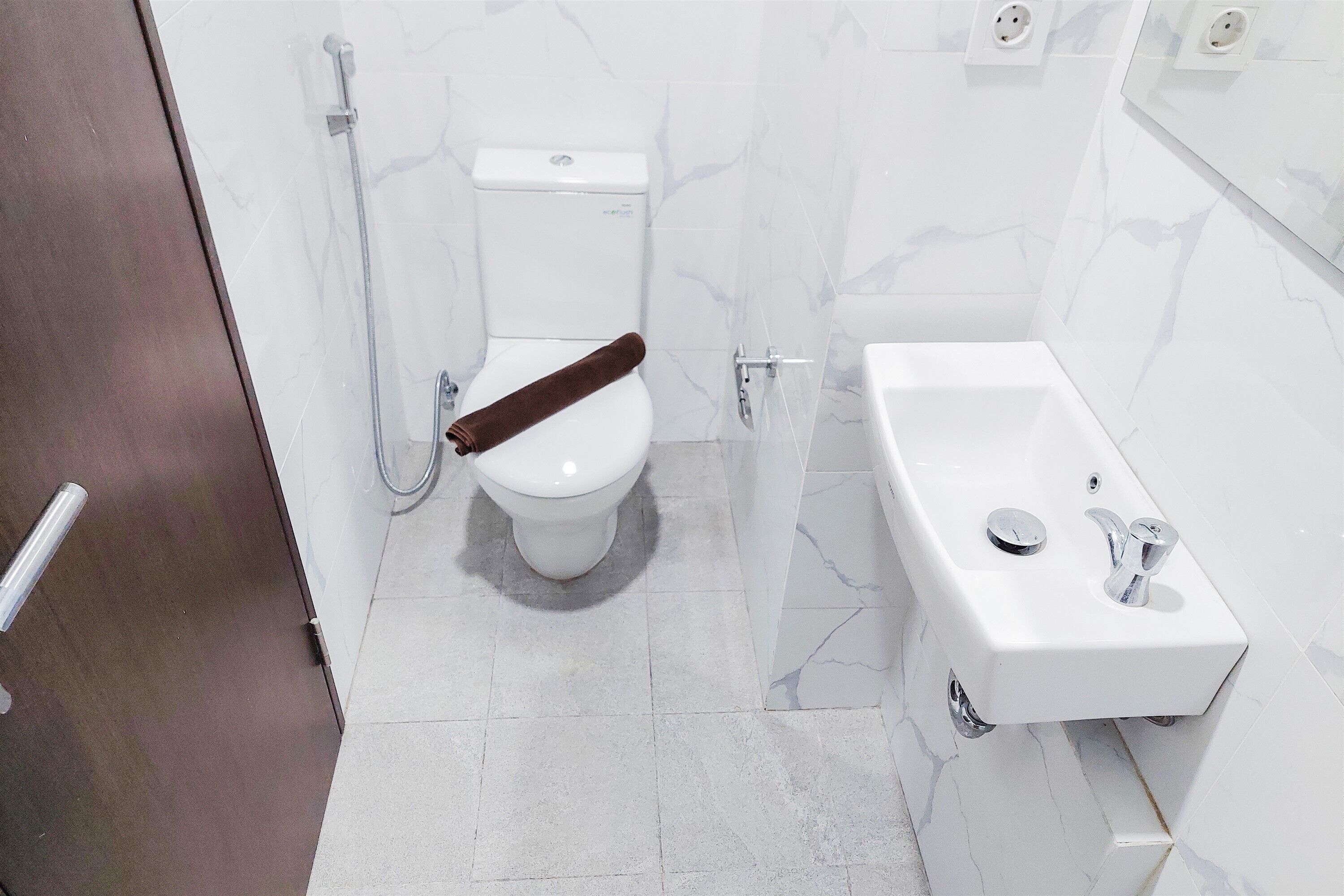 A bathroom with a toilet, a shower, and a sink.