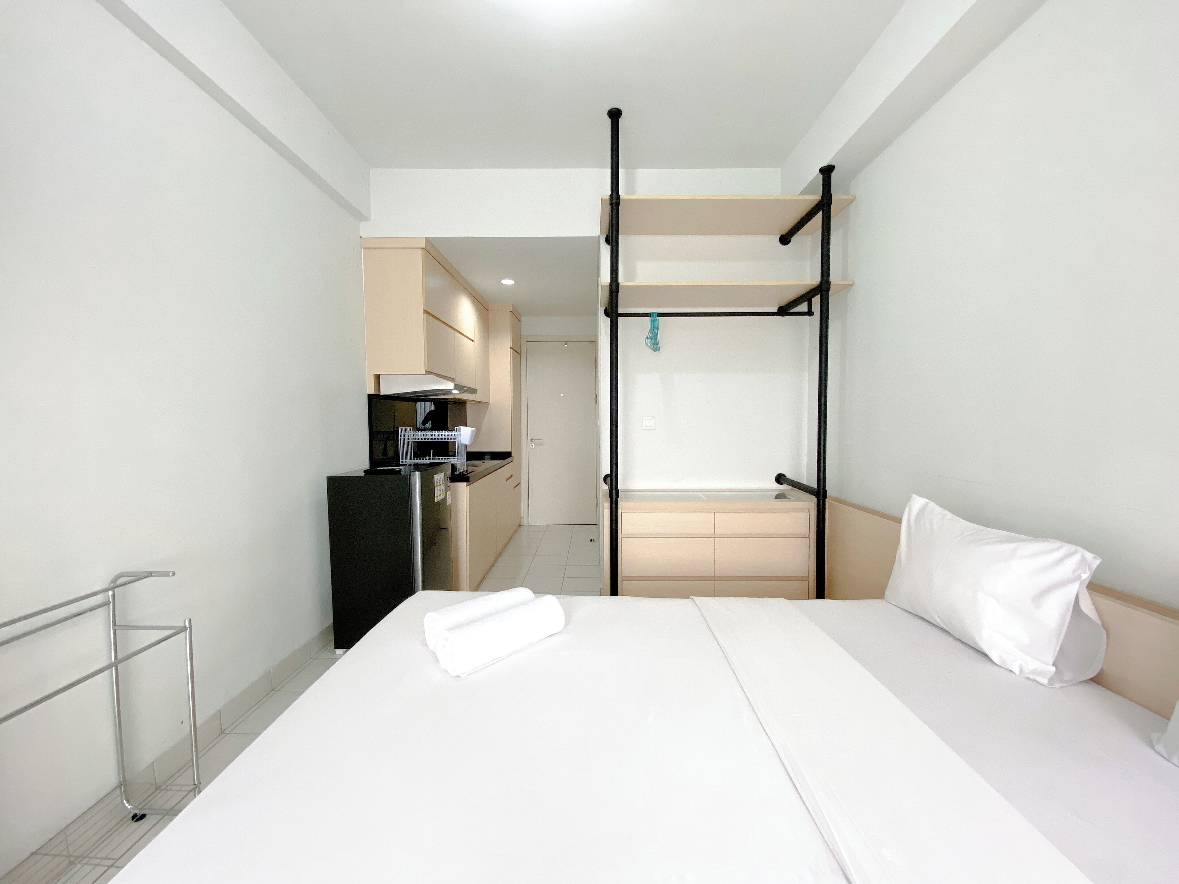 Una habitación de hotel con literas, kitchenette y un baño pequeño.