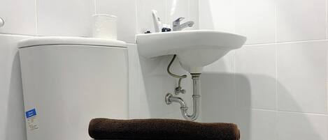 A bathroom with a toilet, a sink, and a towel.