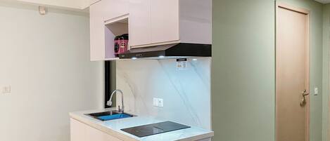 A compact kitchenette with a built-in stove, sink, and a small countertop.