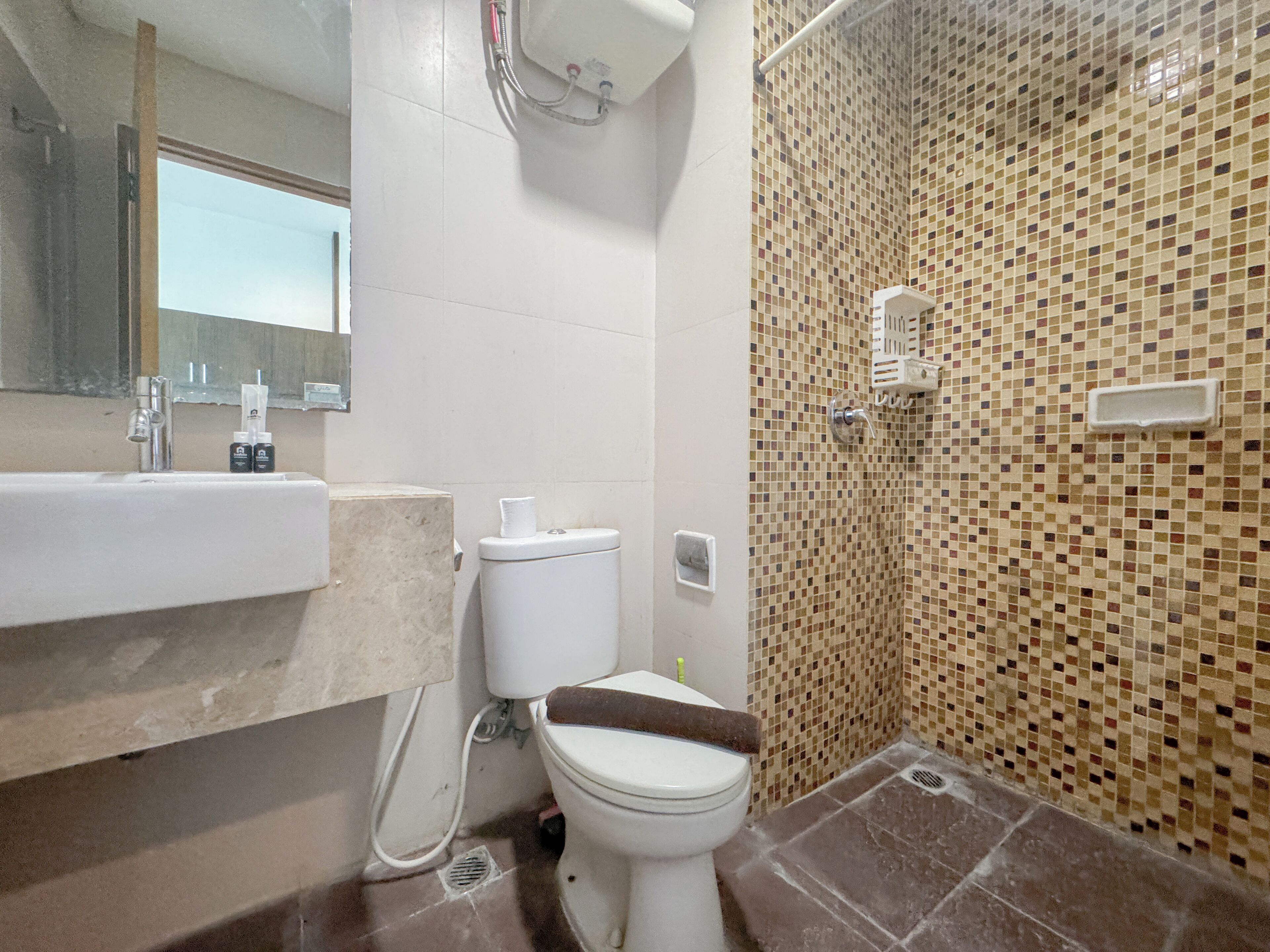 A bathroom with a toilet, sink, and shower area.