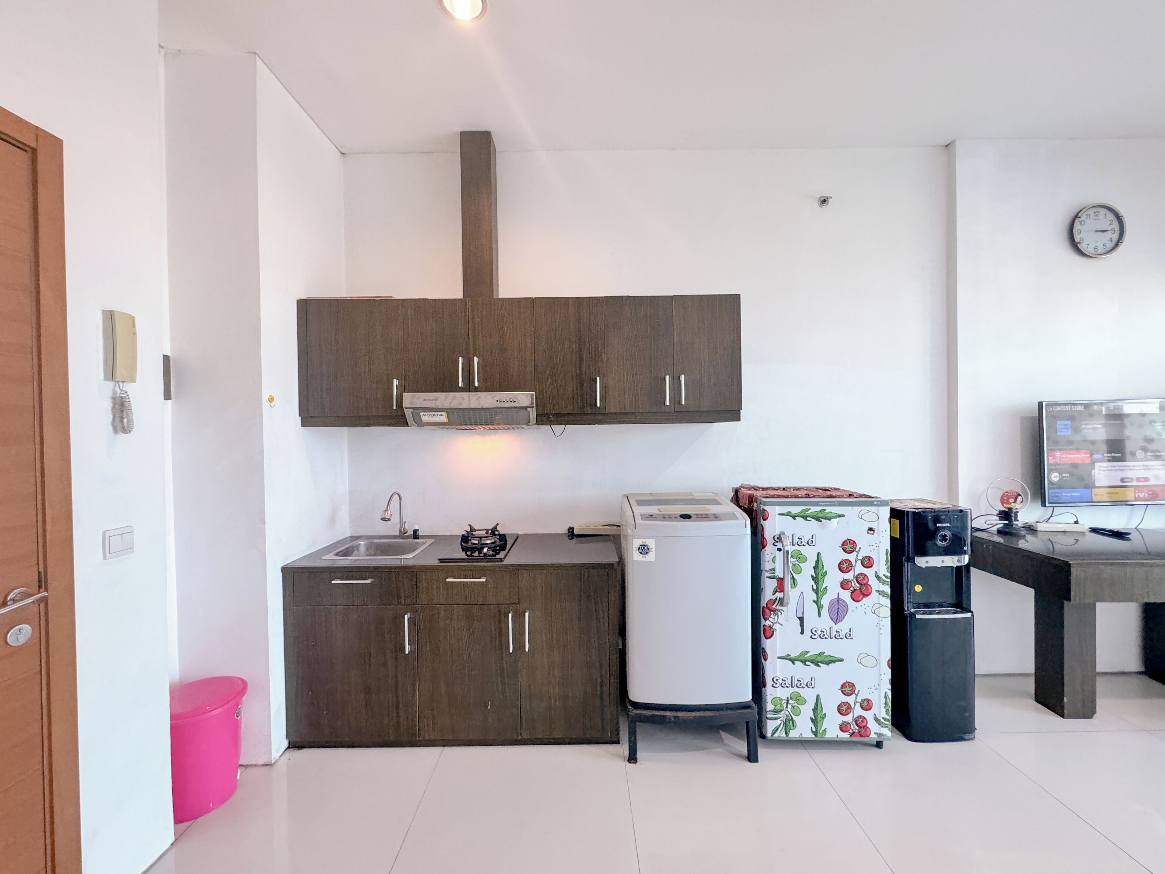 A compact kitchen with dark wooden cabinets, a white refrigerator, a small sink, and a stove.