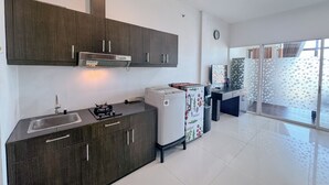 Eine moderne Küche mit dunklen Holzschränken, einem eingebauten Herd und einem Kühlschrank.