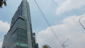 Ein hoher, moderner Wolkenkratzer mit Glasfassade und einem markanten vertikalen Designelement.