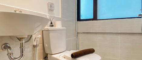 Un baño con lavamanos, inodoro y bañera blancos.