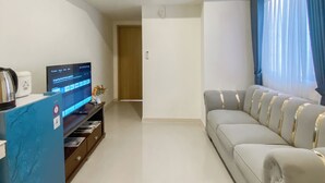 A modern living room with a flat-screen TV, a coffee machine, and a sofa.