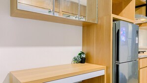 Eine moderne Küche mit Holzschränken, einem Edelstahlkühlschrank und einer Holz Arbeitsplatte.
