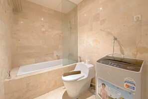 A bathroom with a bathtub, toilet, and a water heater. - Wonderful And Homey 1Br Apartment The Empyreal Epicentrum Kuningan (Jakarta)