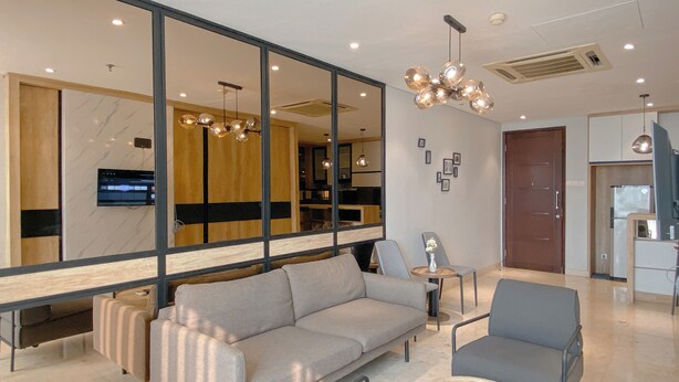 A modern living room with a sofa, armchairs, a coffee table, and a TV. - Wonderful And Homey 1Br Apartment The Empyreal Epicentrum Kuningan (Jakarta)