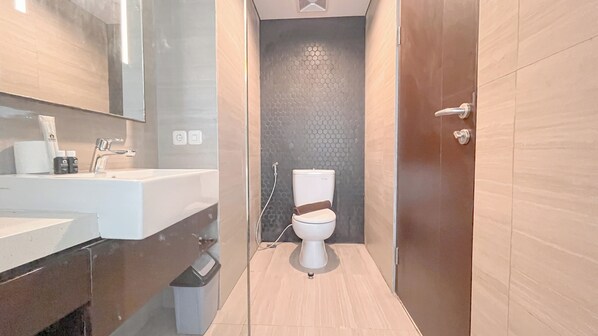 A modern bathroom with a white sink, mirror, and toilet. - Studio Skales Residence Near Nusa Dua Beach Bali (Nusa Dua)