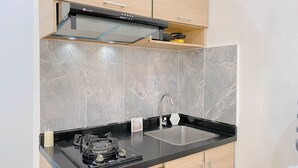 A modern kitchen with a black countertop, a stainless steel sink, and a built-in stove.
